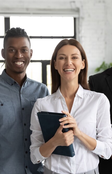 A group of people standing next to each other smiling 
