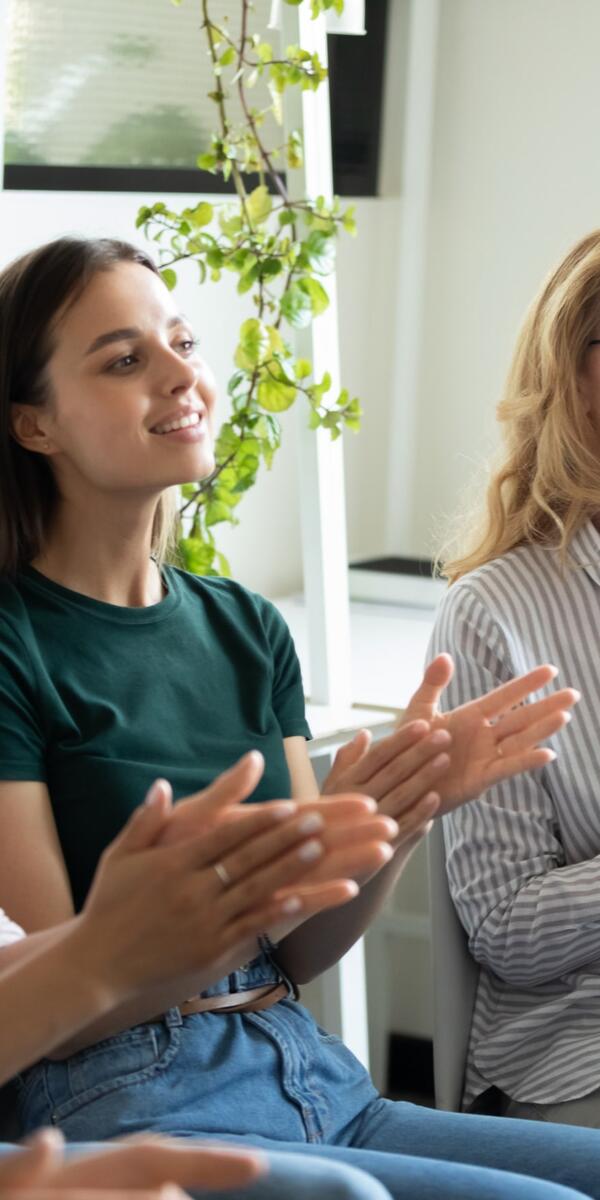 Three seated women clapping