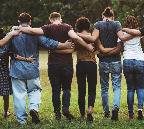 Six people linking arms while walking away 