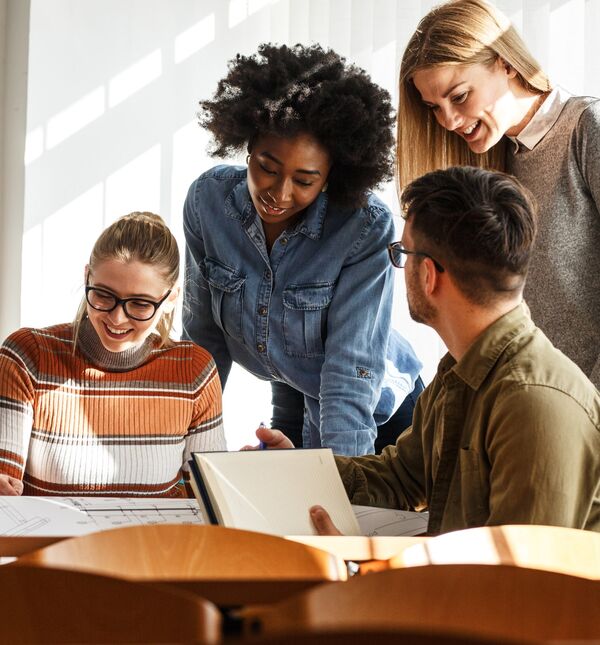 Group of people staring down at the documents scattered on a table