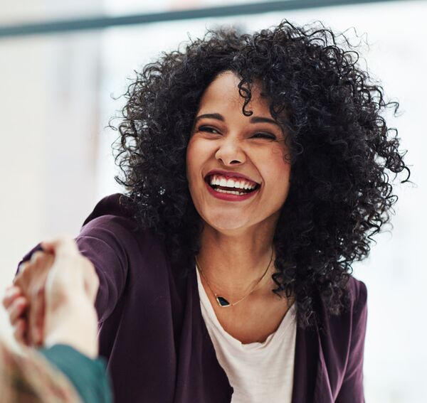 Cheerful black woman shaking hands